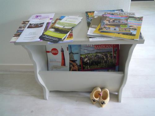 - une table avec des magazines et des livres dans l'établissement Bed en Breakfast de Houtwiel, à De Valom