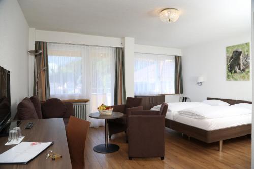 um quarto de hotel com uma cama, uma mesa e cadeiras em Hotel Crystal Interlaken em Interlaken