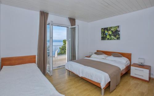 a bedroom with two beds and a balcony at Villa Dalmatia Apartments in Brela
