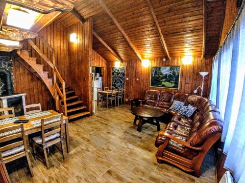 a living room with leather furniture and a staircase at Chata ZEBRA in Ružomberok