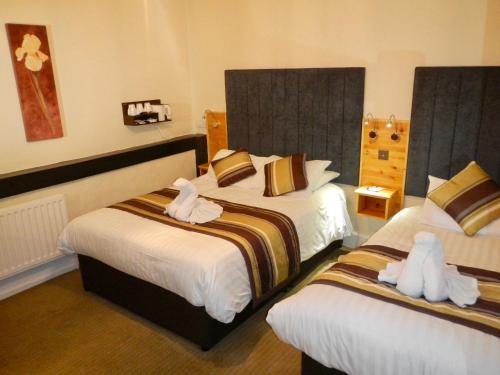a hotel room with two beds with towels on them at Burton Hotel in Kington