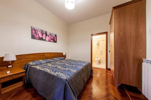 a bedroom with a bed and a dresser and a door at Hotel Domus Praetoria in Rome