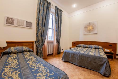 a bedroom with two beds and a window at Hotel Domus Praetoria in Rome