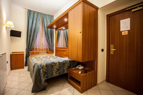 a small bedroom with a bed and a cabinet at Hotel Domus Praetoria in Rome