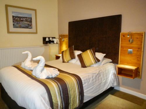 a hotel room with a bed with swans on it at Burton Hotel in Kington