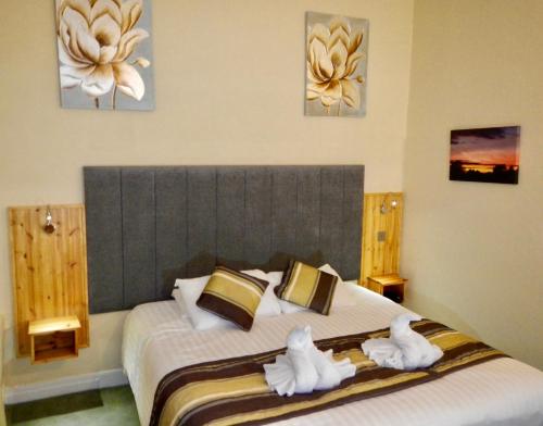 a bedroom with a large bed with towels on it at Burton Hotel in Kington