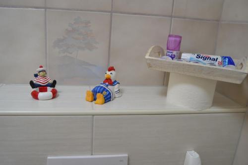 two rubber ducks sitting on a shelf in a bathroom at Haus Schimmelreiter in Greetsiel