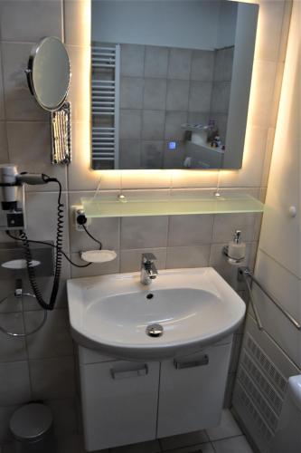 a bathroom with a white sink and a mirror at Haus Schimmelreiter in Greetsiel