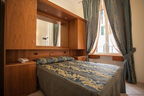 a bedroom with a bed with a mirror and a window at Hotel Domus Praetoria in Rome
