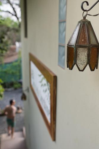 a lamp hanging on a wall with a man walking down the stairs at Tamarindo Sunshine in Tamarindo