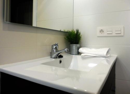 um lavatório de casa de banho com uma torneira e um espelho em Ático en Pamplona em Barañáin