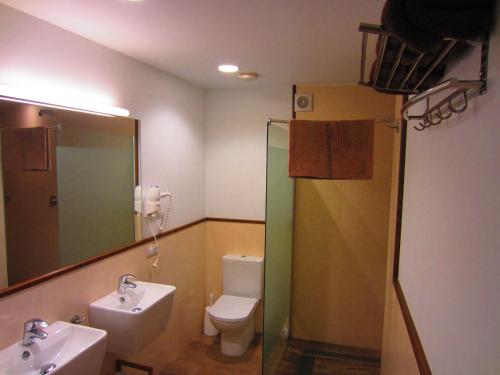 W łazience znajduje się umywalka, toaleta i lustro. w obiekcie Matxitxulo Family Rooms w mieście Ezkurra