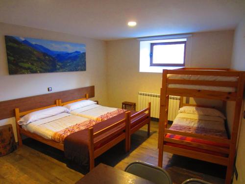 a bedroom with two bunk beds and a window at Matxitxulo Family Rooms in Ezkurra