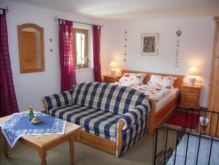 ein Wohnzimmer mit einem Bett und einem Sofa in der Unterkunft Zum Alten Forsthaus in Reit im Winkl
