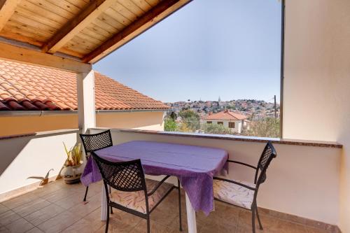 uma mesa roxa e cadeiras numa varanda em Apartmani Dorita em Mali Lošinj