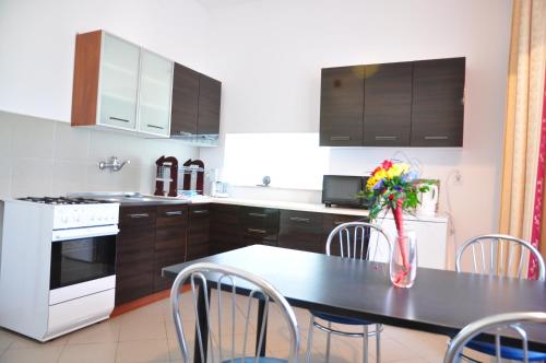 a kitchen with a table with chairs and a white oven at Villa Swarzewo in Swarzewo