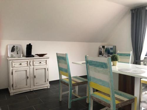 eine Küche mit einem Tisch, 2 Stühlen und einer Theke in der Unterkunft Ferienwohnung Jodis in Bonerath