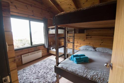 a bedroom with bunk beds in a log cabin at Porters Lodge in Castle Hill