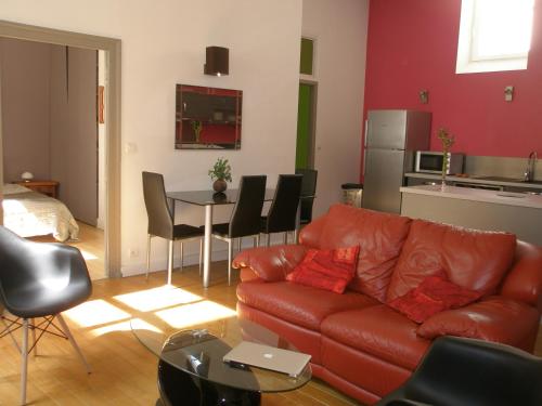 un salon avec un canapé et une table avec des chaises dans l'établissement Rochais, à La Rochelle