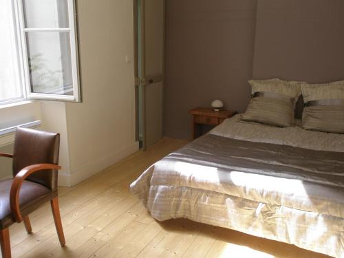 une chambre avec un lit, une chaise et une fenêtre dans l'établissement Rochais, à La Rochelle
