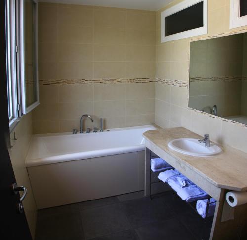a bathroom with a bath tub and a sink at L'Attrachju in Corte