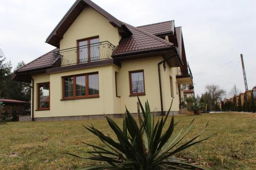 a yellow house with a black roof at Pokoje Gościnne Сisza in Białowieża
