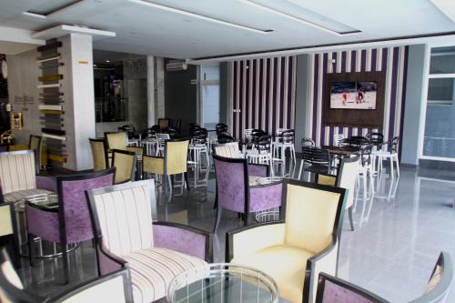 un comedor con mesas y sillas con sillas moradas en Hotel Monte Carlo en Maputo