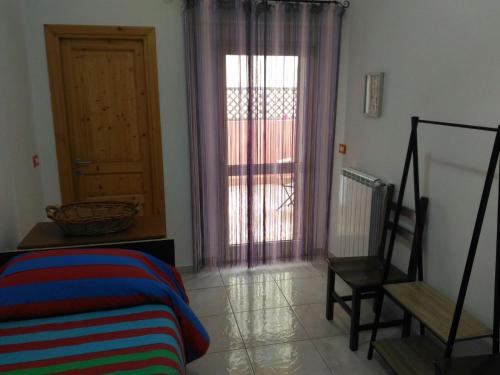 a room with a bed and a chair and a door at Dimora Marisa in Termoli