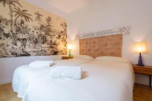 アルムニェーカルにあるCentral Almuñecar, Beach Playa 125 metres, by Old Townの壁に絵画が描かれた客室内の白いベッド2台