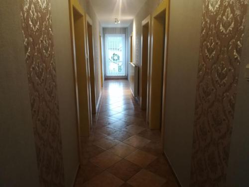 a hallway with a door and a tile floor at Ubytovanie Tri sestry in Hrabušice