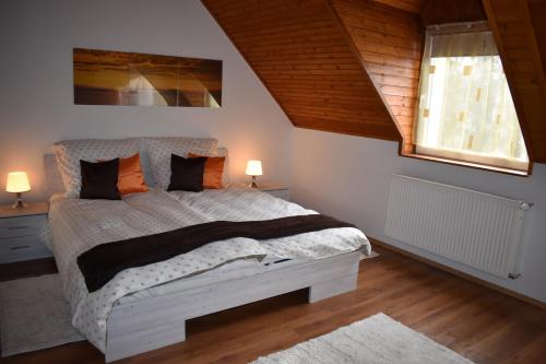 ein Schlafzimmer mit einem großen Bett mit zwei Nachttischen und einem Fenster in der Unterkunft Villa Lily in Zamárdi