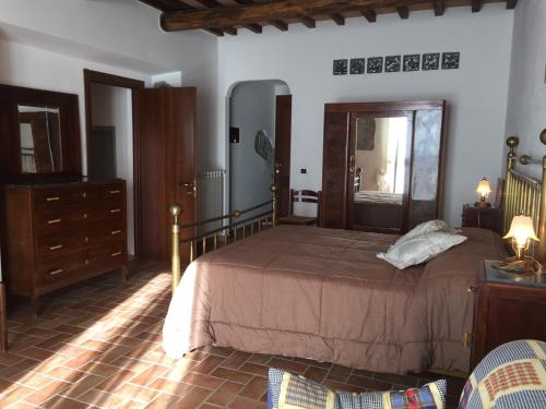 a bedroom with a large bed and a dresser at Poggio Moretto in Manciano