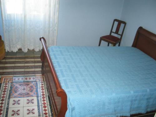 a bedroom with a bed and a chair in a room at Chez Annie in Tuchan
