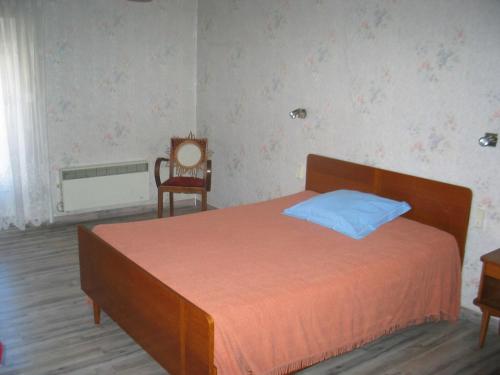 a bedroom with a large bed and a chair at Chez Annie in Tuchan