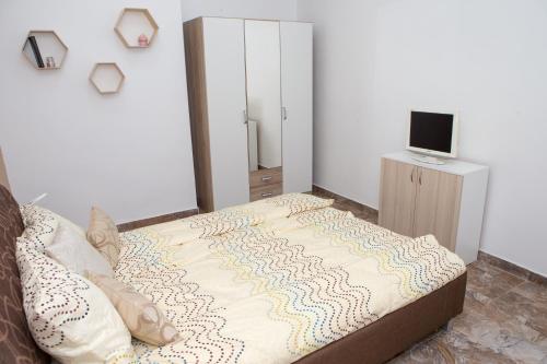 Revolution Apartment في تيميشوارا: غرفة نوم مع سرير وتلفزيون على خزانة
