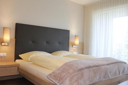 a bedroom with a large bed with a black headboard at Apartment Hotel Christine in Avelengo