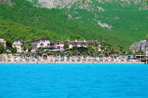 a beach with a bunch of chairs and a resort at Seagull Hotel in Beldibi