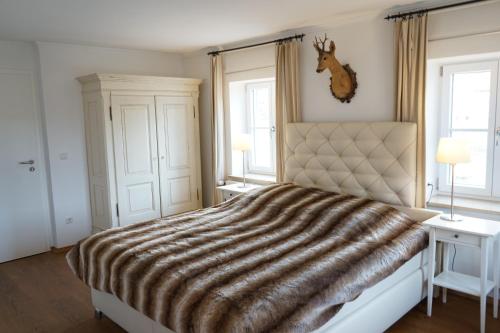 a bedroom with a large bed with a deer head on the wall at Mara Restaurant & Hotel in Dießen am Ammersee