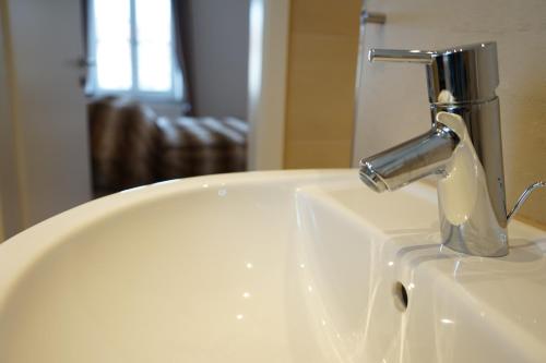 a bathroom sink with a faucet on top of it at Mara Restaurant & Hotel in Dießen am Ammersee