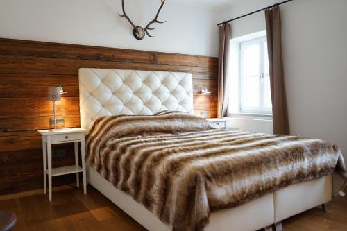 una camera con un grande letto e una finestra di Mara Restaurant & Hotel a Diessen am Ammersee