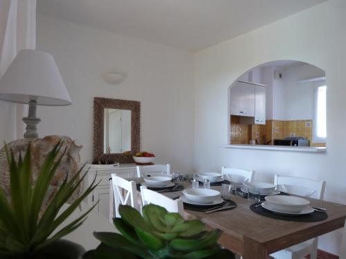 une salle à manger avec une table, des chaises et un miroir dans l'établissement Jardins du Port Les Issambres - Meublé de Tourisme - Front de mer - Clim, à La Garonnette-Plage