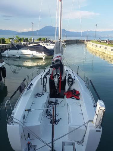 a white boat docked in the water at a dock at Yachting Hotel Mistral in Sirmione