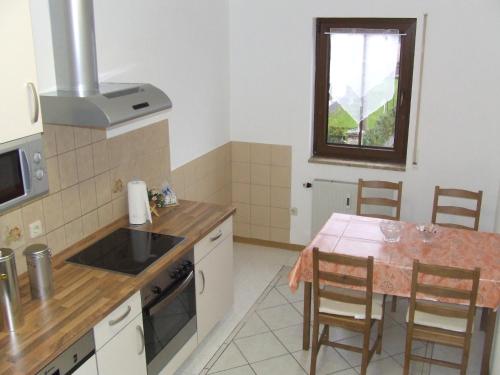 uma cozinha com uma mesa e uma bancada em Apartment fewobaerenstein em Bärenstein