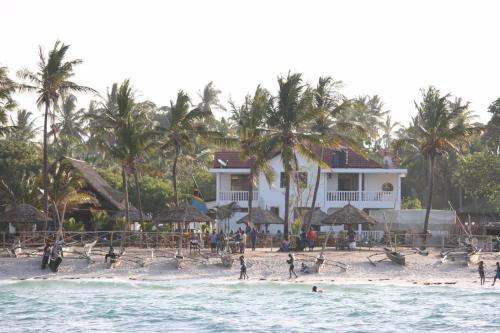 a group of people on a beach near a house at Villa Dahl Beach Resort in Dar es Salaam