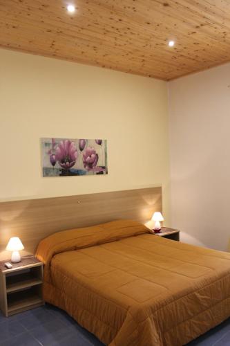 um quarto com uma cama com duas mesas de cabeceira e dois candeeiros em Appartamento Stella del mare em Trapani