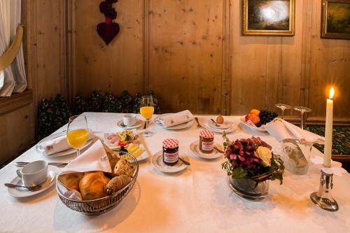 a table with a white table cloth with food and a candle at Hotel Zum Pinzger in Stumm