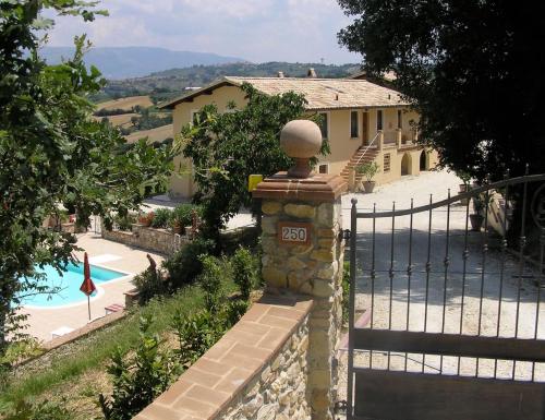 una casa con una puerta y una piscina en Genius Loci Country Inn, en Bevagna