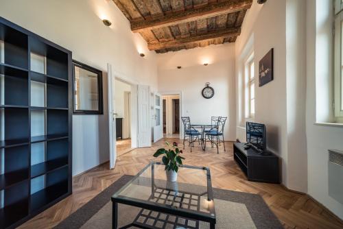 a living room with a glass table and chairs at St. George Apartments in Prague