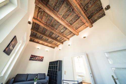 a living room with a blue couch and a wooden ceiling at St. George Apartments in Prague
