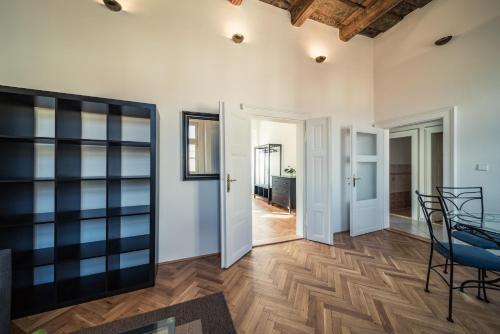 a living room with a wooden floor and a table and chairs at St. George Apartments in Prague